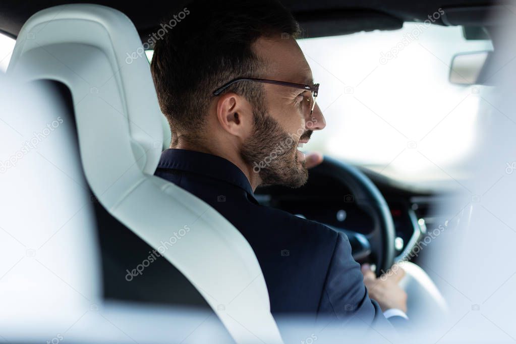 Handsome man smiling while driving home in the evening