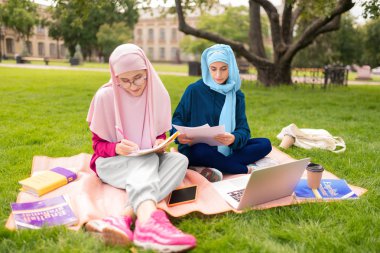Dışarıda oturan başörtüsü takan kara gözlü Müslüman kadın