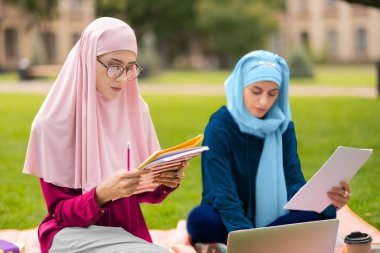 Güzel müslüman öğrenci arkadaşı ile çalışma gözlük giyiyor