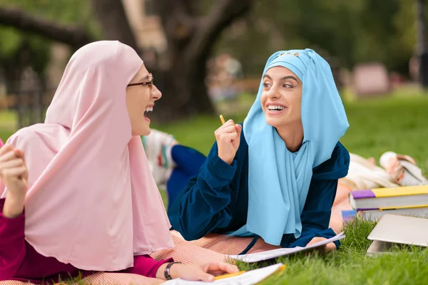 Muslim student wearing glasses studying outside with friend — Stock Photo, Image