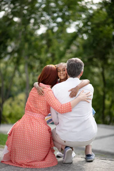 Mature couple hugging cute lovely girl after adoption — Stock Photo, Image