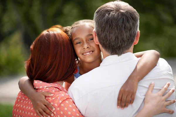 Oscuro de piel atractiva linda chica abrazando a los padres adoptivos — Foto de Stock