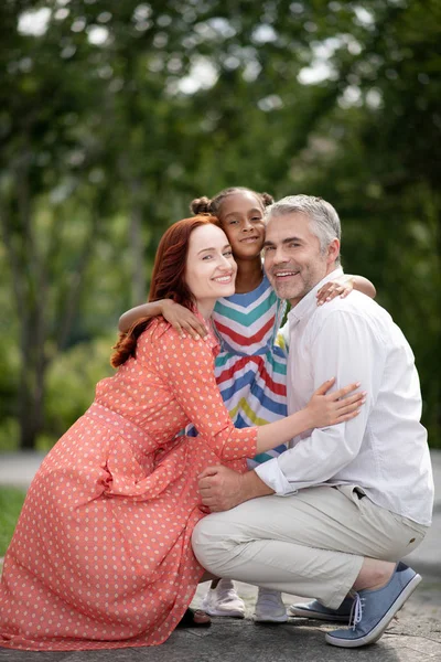 Hombre y mujer sintiéndose feliz después de la adopción de linda chica — Foto de Stock