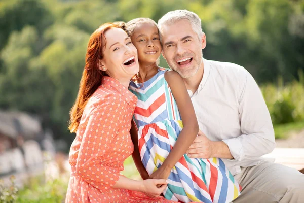 Coppia matura sorridente mentre trascorre del tempo con la figlia — Foto Stock