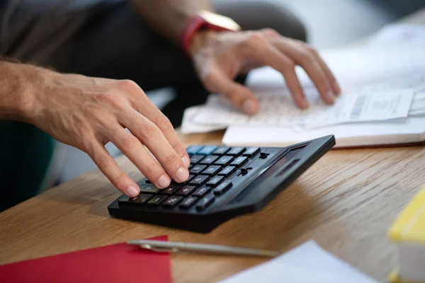 Primer plano del hombre de negocios utilizando la calculadora que se encuentra cerca de la pluma — Foto de Stock