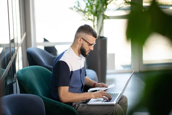 Young businessman working on laptop doing accounting