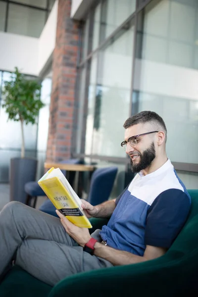 Elegante hombre de negocios guapo sentado y leyendo libro — Foto de Stock