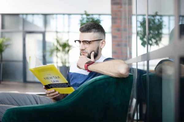 Empresário sentado em poltrona e livro de leitura — Fotografia de Stock