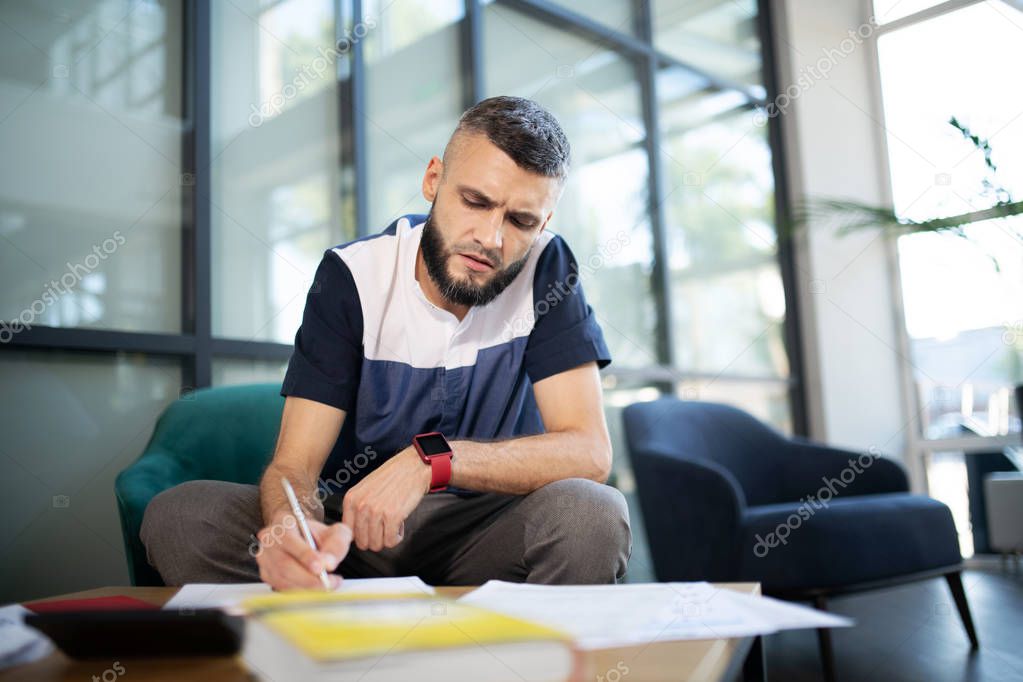 Bearded man feeling overloaded with accounting