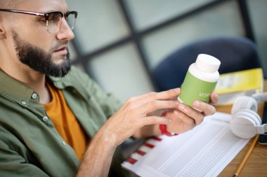 Sakallı yakışıklı adam gözlük vitaminler hakkında okuma