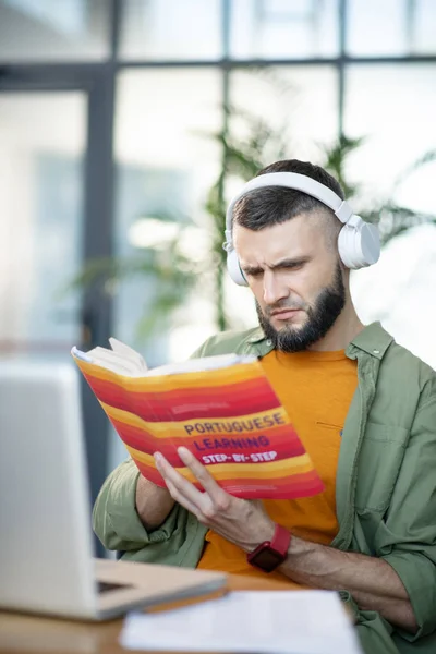Hombre barbudo escuchando y estudiando portugués —  Fotos de Stock