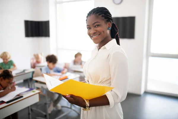 Schöne Lehrerin lächelt, während sie den Unterricht genießt — Stockfoto