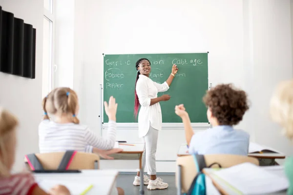 Aktive Kinder heben die Hände, während sie die Antwort kennen — Stockfoto