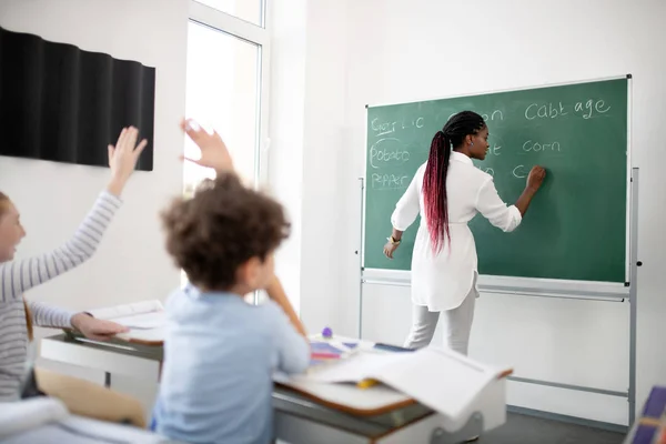 Mörkhyade lärare skriver ner på Blackboard för barn — Stockfoto