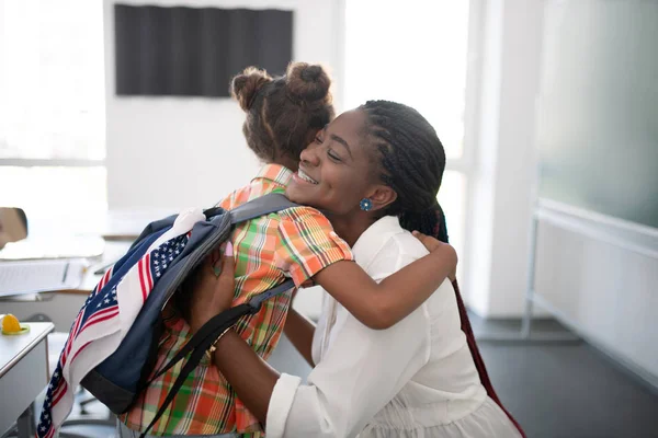 Chica abrazando a su agradable maestro mientras se siente agradecido —  Fotos de Stock