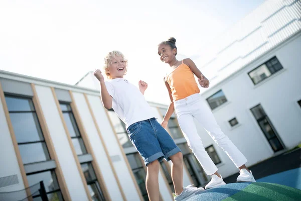 Веселый смеющийся мальчик и девочка веселятся на улице — стоковое фото