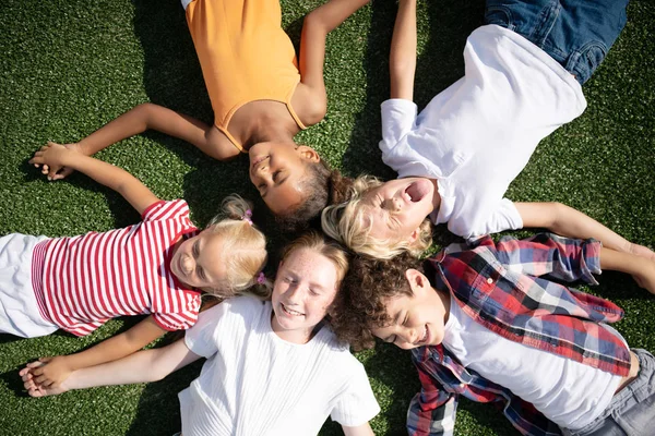 Kinder machen lustige Gesichter beim Chillen im Gras — Stockfoto