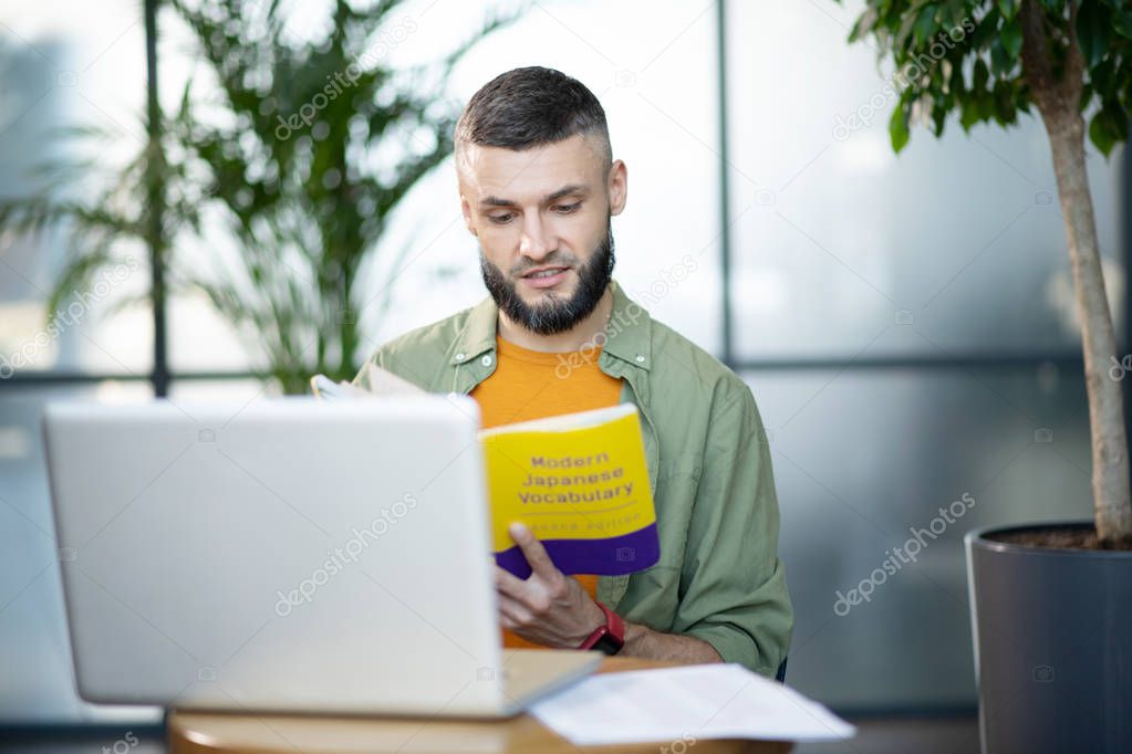 Bearded businessman studying modern Japanese vocabulary