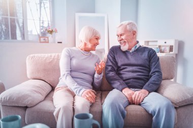 Kanepede oturan ve sohbet emekli adam ve kadın ışınlama çift