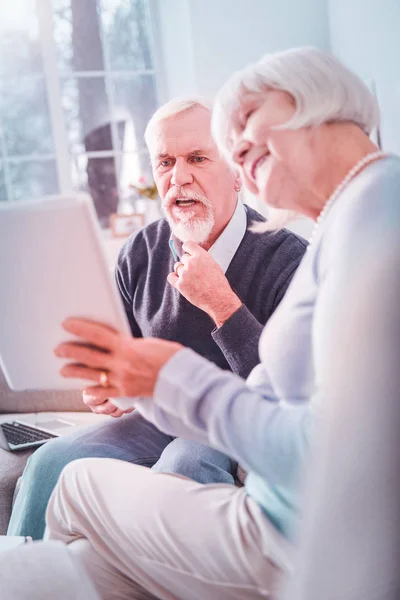 Современная пара пенсионеров, использующих свои планшетные покупки онлайн — стоковое фото