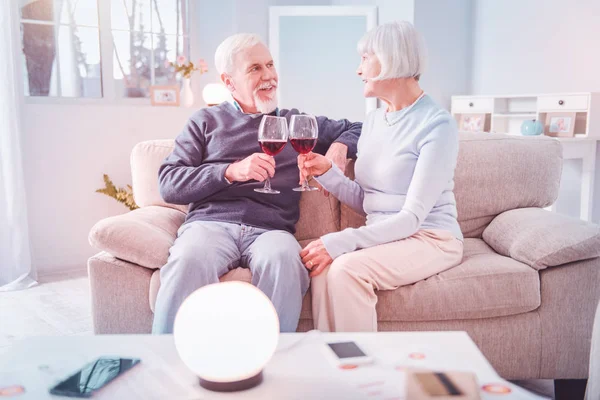 Pareja de pensionistas bebiendo vino tinto mientras tienen una cita romántica — Foto de Stock
