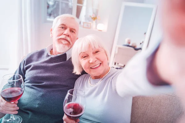 Blonde-haired woman smiling while making photo with husband