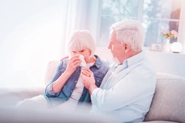 Bearded retired husband supporting his woman crying after bad news