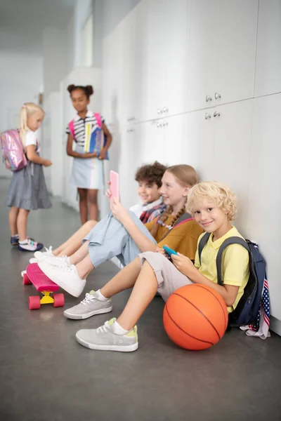 Les enfants apprécient la pause scolaire jouer à des jeux vidéo et parler — Photo