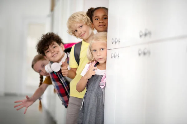 Fröhliche Kinder stehen in der Schulpause neben Schließfächern — Stockfoto