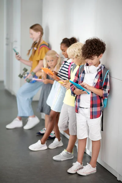 Παιδιά με gadget περνούν το διάλειμμά τους παίζοντας παιχνίδια — Φωτογραφία Αρχείου