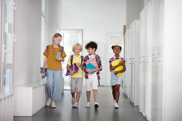 Elèves portant des sacs à dos marchant ensemble vers la salle de classe — Photo