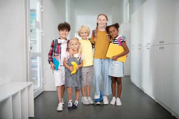 Amistosos alumnos agradables abrazándose entre sí — Foto de Stock