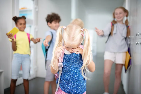 Kleines Mädchen weint, während es sich von Mitschülern beleidigt fühlt — Stockfoto