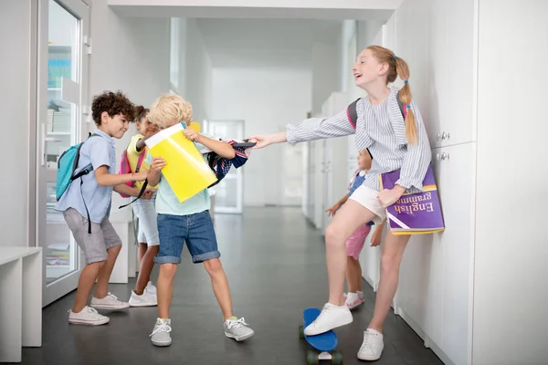 Children offending and bullying boy near lockers — Stock Photo, Image