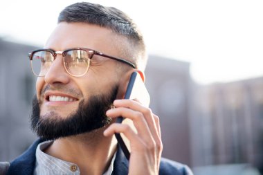 Yakışıklı adam telefonla kız arkadaşı ile konuşurken gülümseyen