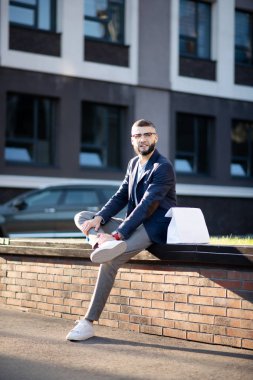 Ofis binasıyakınında dışarıda oturan yakışıklı şık adam