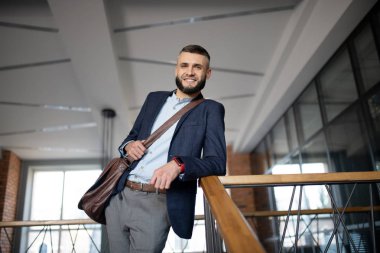 Merdivenlerin yanında duran akıllı saat takan ışınlama ofis çalışanı