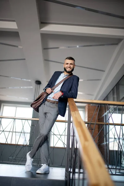 Bonito homem de negócios elegante de pé no escritório — Fotografia de Stock