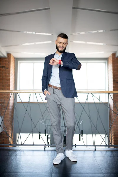 Bearded businessman checking time while running late for meeting — Stock Photo, Image