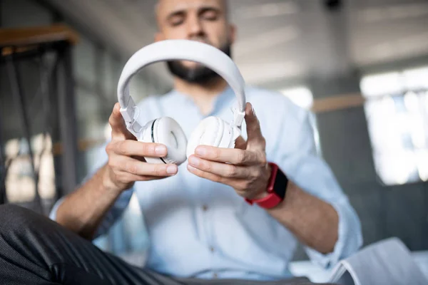 Man holding white earphones while having break from work
