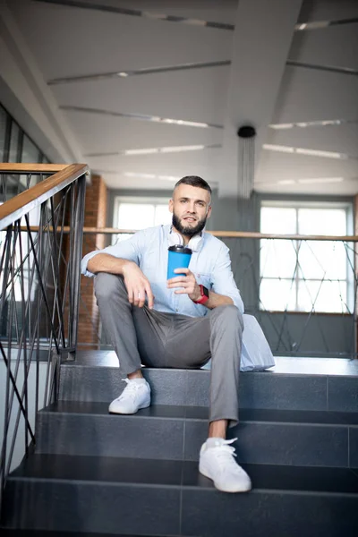 Trabalhador de escritório sentado nas escadas e beber café takeaway — Fotografia de Stock