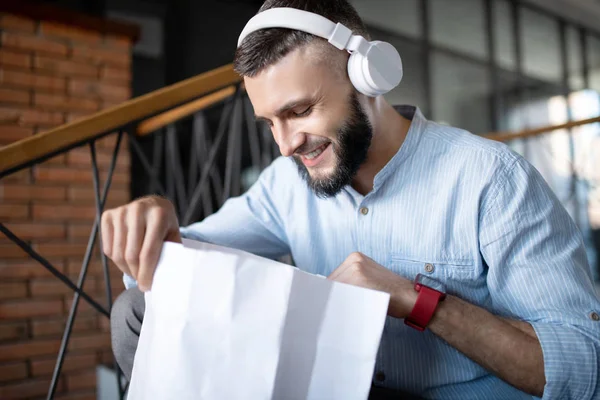 Bearded businessman looking into bag after receiving parcel — Stock Photo, Image