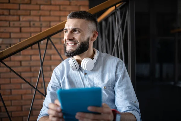 Smiling man holding little tablet while having little break — Stock Photo, Image