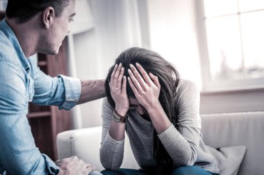 Ağlayan koyu saçlı karısını teselli eden şefkatli erkek arkadaşı