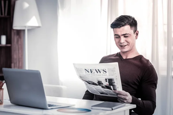 Lächelnder Mann mit stylischem Haarschnitt amüsiert sich über Informationen — Stockfoto