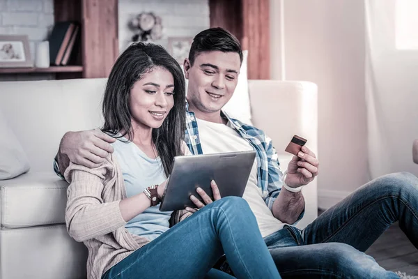 Smiling appealing couple sitting on the cozy couch — Stock Photo, Image