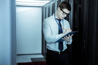 Mavi gömlekli genç adam not ala