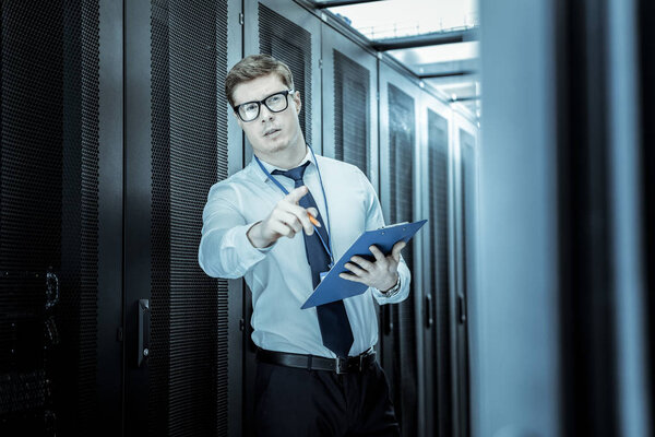 Элегантный молодой человек в очках работает в офисе
