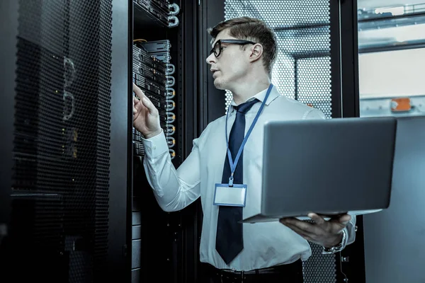 Tall investigator in eyeglasses checking up server security