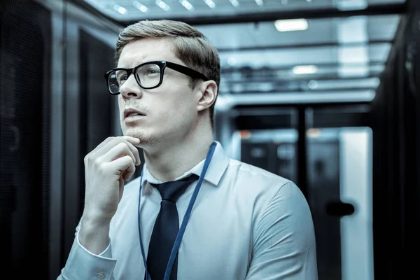 Homem de camisa azul e óculos olhando pensativo — Fotografia de Stock